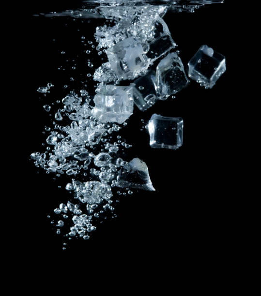 istock Ice cubes into the water with a bubble on black background 1430192780