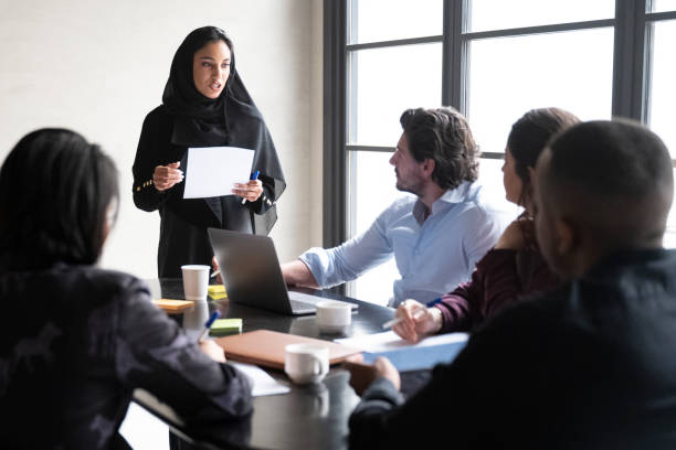joven empresaria saudí presentando ideas de proyectos al equipo - women islam middle eastern ethnicity arabic style fotografías e imágenes de stock