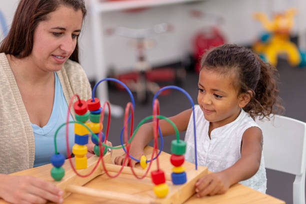 istock Ethnic pre-schooler working with her teacher in a classroom 1430207064