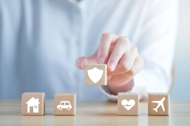 istock Insurance concept. Protection against a possible eventuality. Hand holding security icon and House, Car, Health care and travel icon on wooden block for assurance life concept. 1430207180