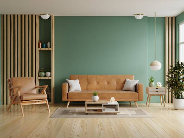 空の濃い緑色の壁の背景に革張りのソファと革張りのアームチェアを備えたリビングルーム。 - contemporary indoors sparse living room ストックフォトと画像