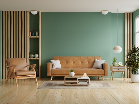 Living room with leather sofa and leather armchair on empty dark green wall background.3d rendering