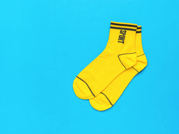 istock Yellow socks with black trim on a blue background. Flat lay. 1430212483