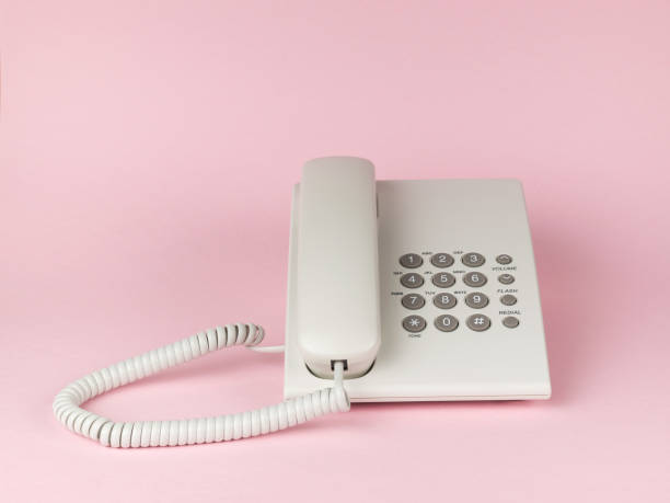istock Stylish white wired office phone on pink background. Flat lay. 1430212485