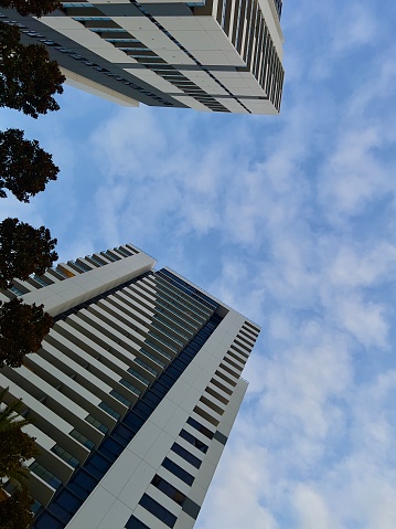 two condominium apartment towers with fine clouds and blue sky