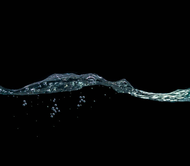 Blue Water waves and air bubbles Blue Water waves and air bubbles. Lots of underwater blue sponges, black background and copy space above. water droplets floating in the air water on black surface stock pictures, royalty-free photos & images