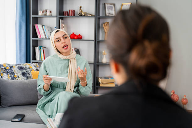 patiente musulmane ayant une séance de psychothérapie au bureau du psychologue - middle eastern ethnicity teenage girls women sadness photos et images de collection