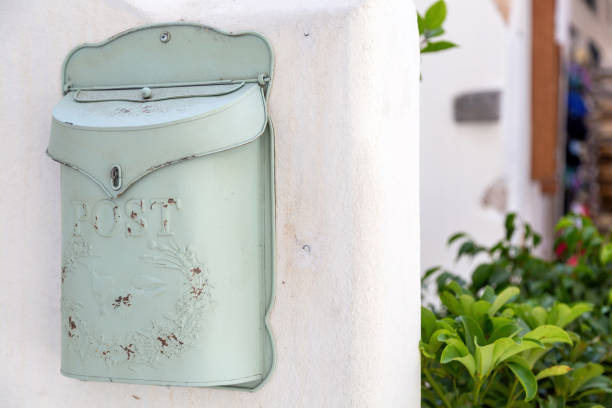 Old rusty metal mailbox on  house wall background. Vintage exterior letterbox, traditional old fashioned design light green postbox.