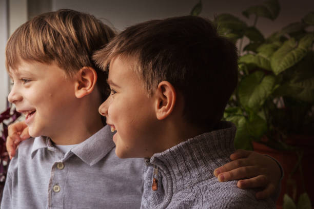istock Two boys laughing and looking out the window 1430237412
