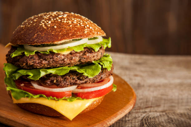 istock Tasty burger with cheese on wooden table 1430237786