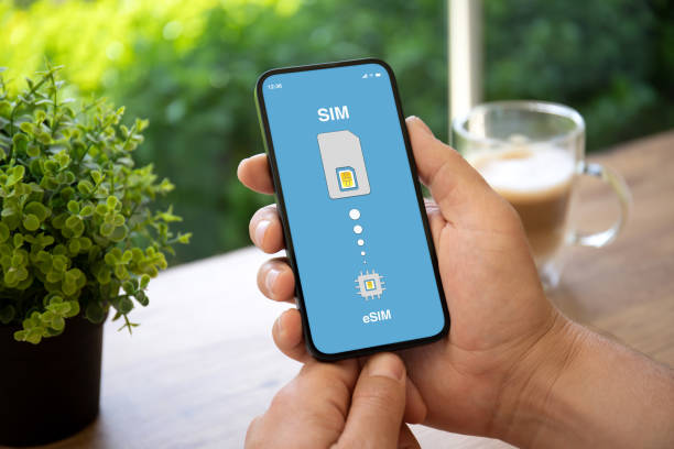 istock man hands holding phone with Sim card replacement on eSim 1430239578