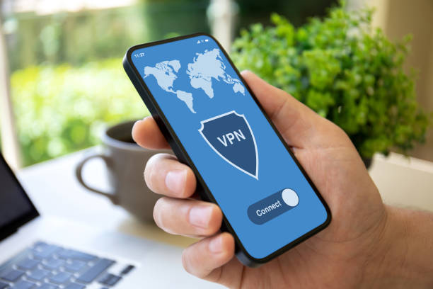 istock male hand holding phone with app vpn over table laptop 1430239773