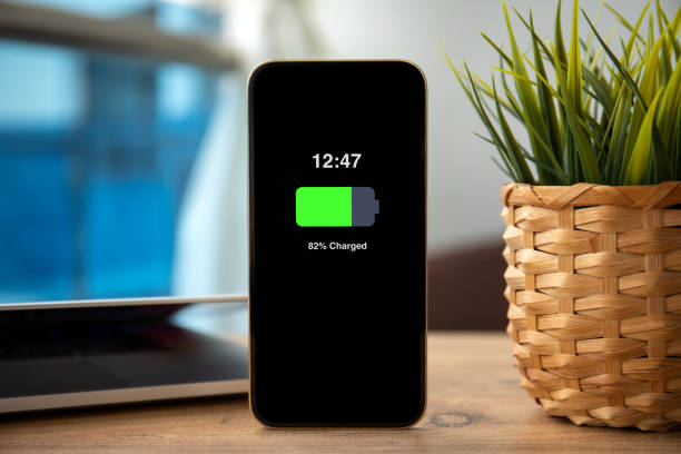 istock Gold Phone with charged battery on the screen in office 1430241063