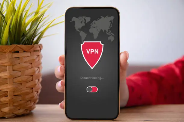 Photo of female hand holding phone with app vpn on the screen