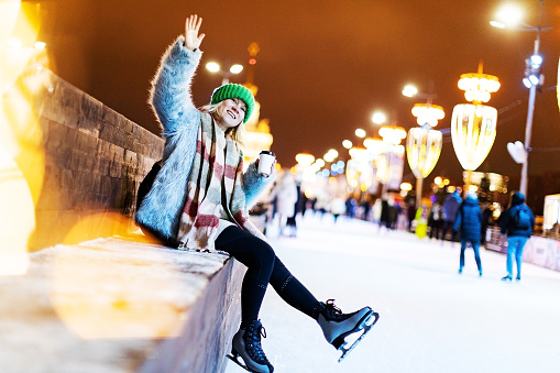Young adult woman celebrating Christmas at ice skating ring