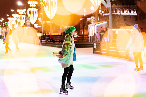 Young adult woman celebrating Christmas at ice skating ring