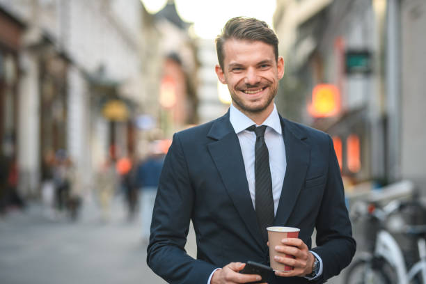 istock Handsome Male Executive with Coffee and Phone Looking at Camera 1430254004