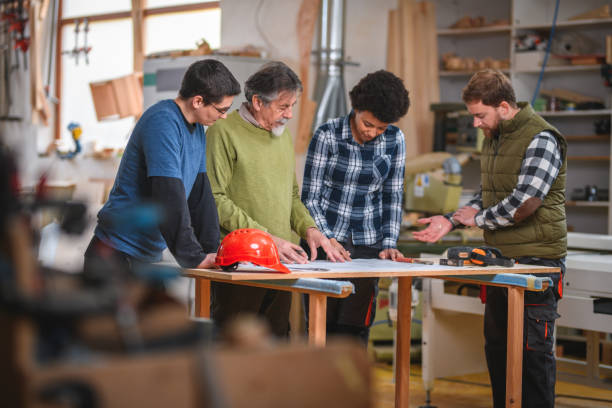 istock Group of Diverse Carpenter Trainees Designing A Blueprint 1430255884
