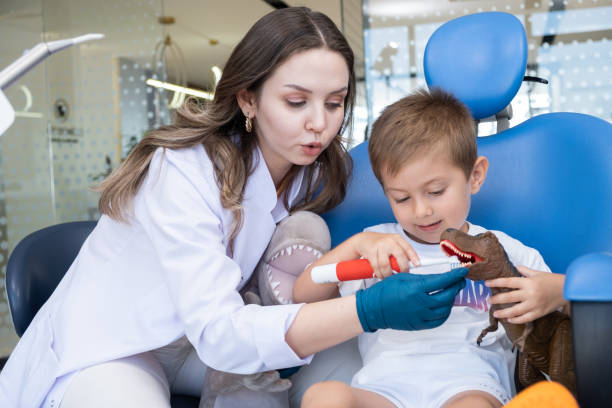 giovane paziente pediatrico sulla poltrona del dentista - scrub brush immagine foto e immagini stock