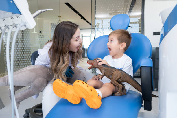 Young Pediatric Patient On Dentist Chair Female dentist talks with young pediatric patient. pediatric dentistry stock pictures, royalty-free photos & images