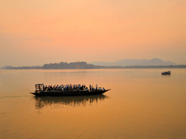 A ferry carrying passengers sailing in river Brahmaputra in Guwahati during sunset. A ferry carrying passengers sailing in river Brahmaputra in Guwahati during sunset. brahmaputra river stock pictures, royalty-free photos & images