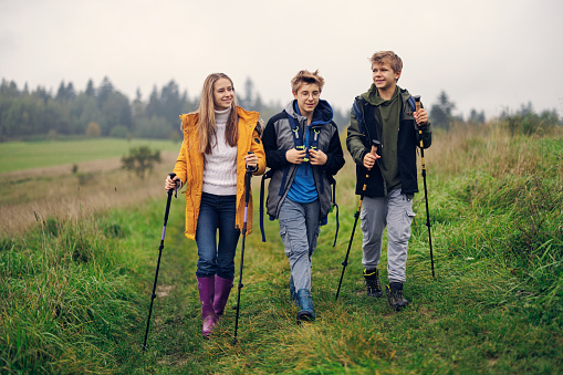 Three teenagers hiking in Island Beskids in southern Poland on autumn, rainy, October day. They are walking on path in meadows and hills.
Canon R5