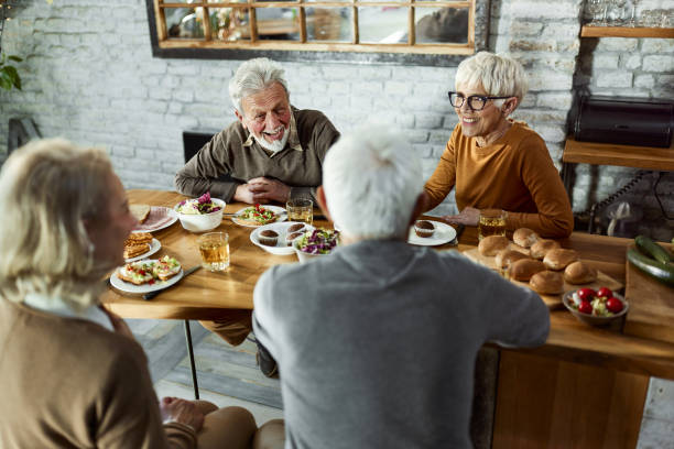 istock Happy mature couples enjoying in conversation during a meal at dining table. 1430264135