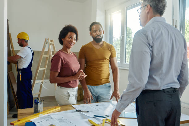 istock Black couple talking about renovation plans with male architect at home. 1430267270
