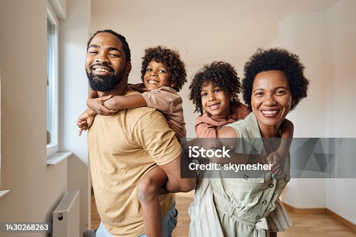 istock Happy African American family piggybacking at their new home. 1430268263