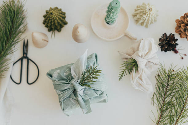 istock Zero waste Christmas flat lay. Stylish wrapped gifts in linen fabric on white rustic table with eco friendly wooden toys, fir branches, candle. Furoshiki gift wrapping. Happy Holidays! 1430268600