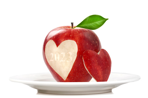 Red apples in heart shape on bright wooden background. Valentines Day concept