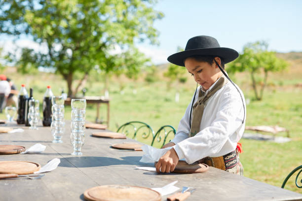 istock Argentine gaucho boy setting table for barbecue 1430278624