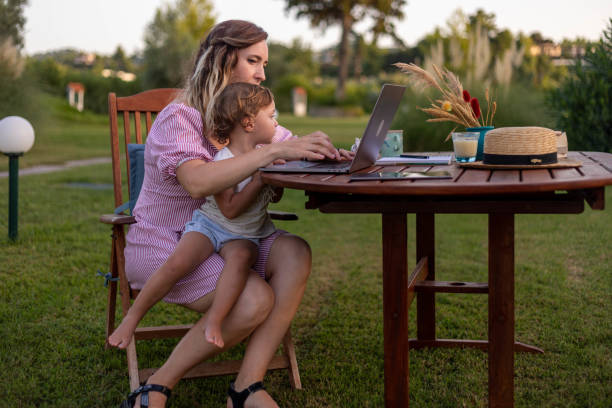 istock A woman works with a child in her lap 1430280587
