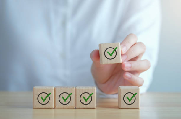 istock Checklist, Task list, Survey and assessment, Quality Control, Goals achievement and business success. Elections and Voting, Vote, to do list, Hand holding green check mark on wooden block. 1430285918