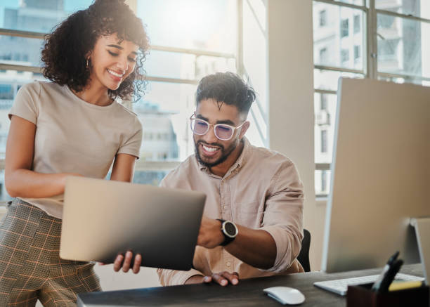 Creative team, laptop and collaboration while talking, helping and brainstorming idea on internet for inspiration or motivation for web design. Diversity with woman and manager man working on project