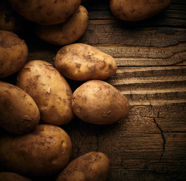 Potatoes over wooden vintage background stock photo