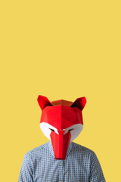 istock man wearing a red fox mask on a yellow background 1430292332