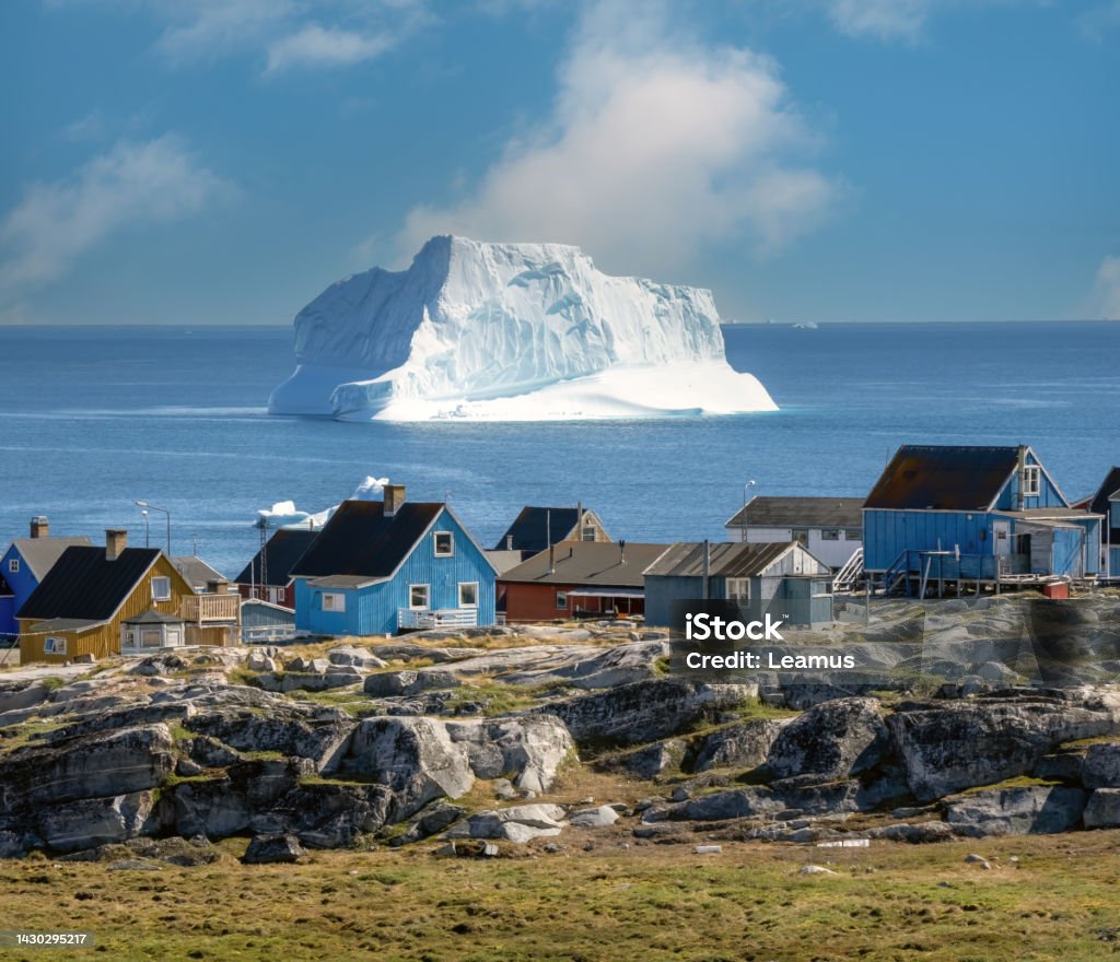 Huge icebergs lining the shores of the charming town of Qeqertarsuaq (formerly Godhavn) on the south coast of Disko Island, Western Greenland. Greenland Stock Photo