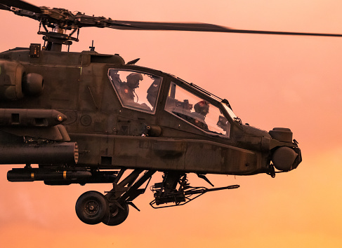Boeing AH-64 Appache attack helicopter in an evening flight
