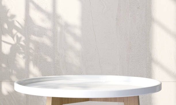 istock Modern white glossy round wooden side table with sunlight and leaf shadow on concrete wall background 1430299803