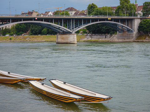 Buildings in the city centre of Basel , Switzerland. boats on the river Rhine