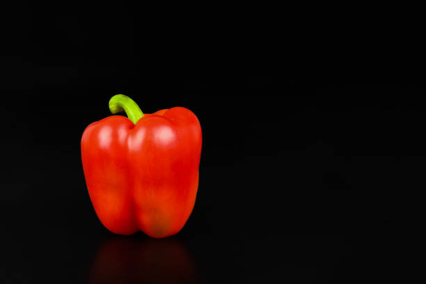 fresh red bell pepper on bamboo strainer on white background
