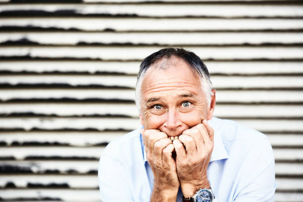 istock Middle-aged man stares at the camera in horror and shock, biting his nails 1430320441