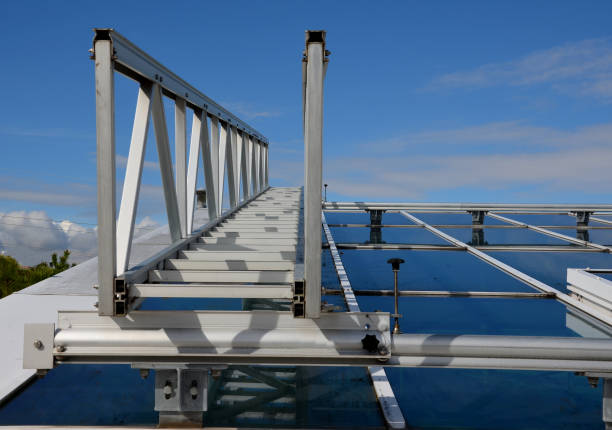 passarela de alumínio para lavar janelas acima da claraboia. simplificando a lavagem de grandes estufas e galerias com janelas de teto. a escada pode ser movida sobre os trilhos, céu azul, espátula - architecture roof aluminum sheet industry - fotografias e filmes do acervo