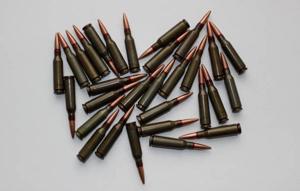 istock Unitary cartridges for assault rifle scattered on a whire surface top view 1430324073