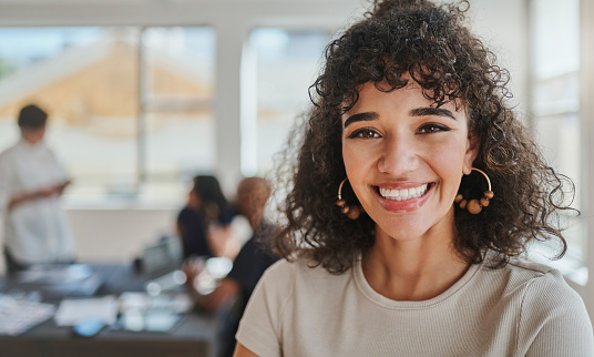 Teamwork, meeting and portrait of business woman in the office. Young black woman in the workplace in successful business meeting with her team. Confident, smart and smiling businesswoman at work