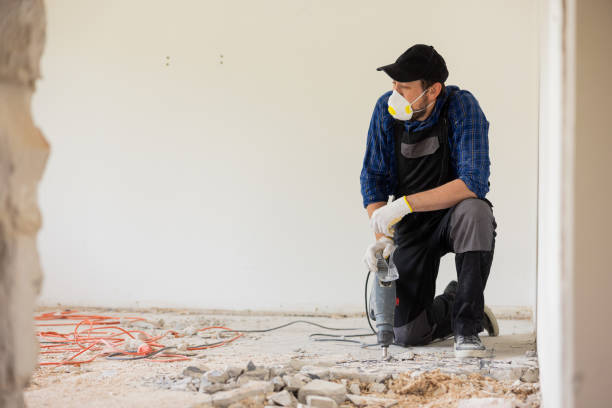 istock A man in a protective work suit wearing a mask and goggles is cupping the floor with a hand-held impact mote to prepare the space for tiles in the kitchen bathroom 1430334488