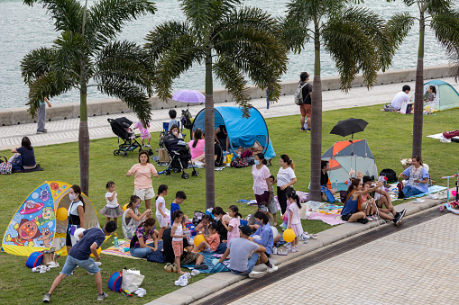 Hong Kong - October 4, 2022 : People enjoying a holiday at the West Kowloon Waterfront Promenade in Hong Kong.