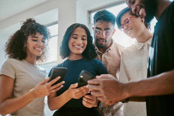 réseautage, travail d’équipe et collaboration téléphonique avec l’équipe numérique travaillant sur le logo de la marque et de l’application dans un bureau. démarrage, vision et diversité avec des collègues partenaires qui planifient le succ� - technology mobile phone people planet photos et images de collection