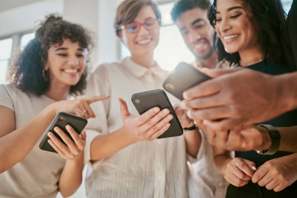 istock Group check social media on smartphone, online teamwork conversation and tech marketing agency. Young team share funny digital meme, happy people laugh together in office and read communication wifi 1430338400